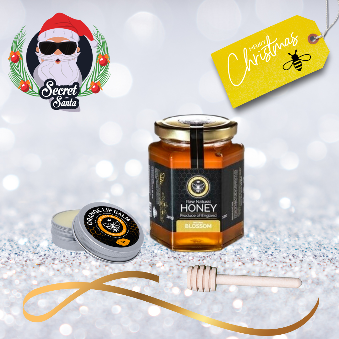 Jar of honey, lip balm, and honey dipper on a festive background with 'Secret Santa' logo.