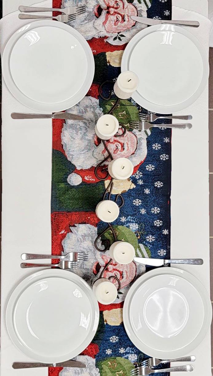 Set of plates and cutlery on a decorative tablecloth with floral patterns.