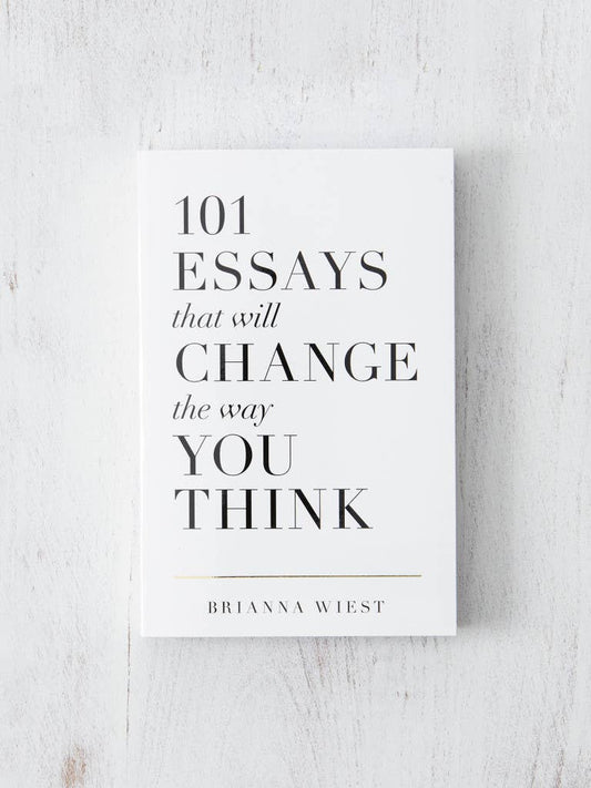Book titled '101 Essays that will Change the Way You Think' by Brianna Wiest on a light wooden surface.