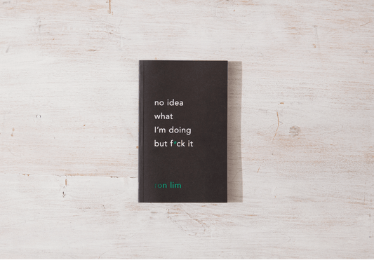 Black book with text on a light wooden surface