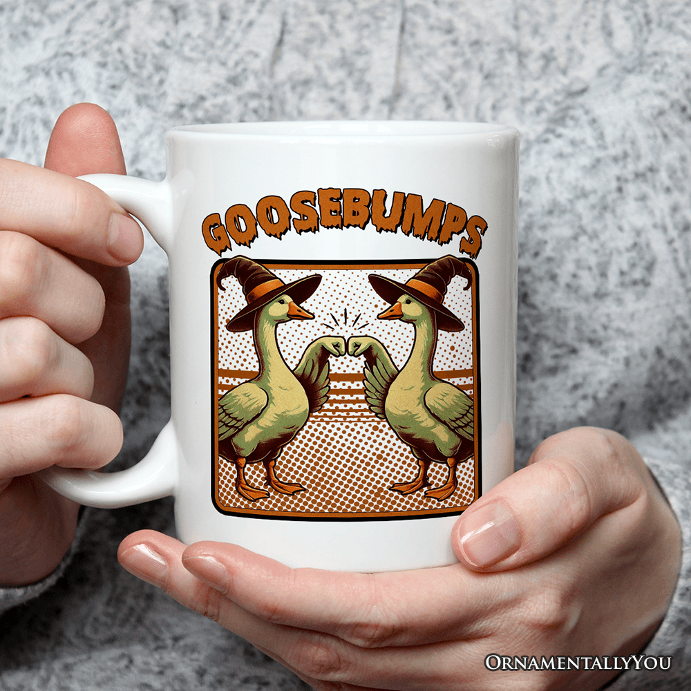 White mug with 'GOOSEBUMPS' design featuring ducks wearing hats, held by a person.