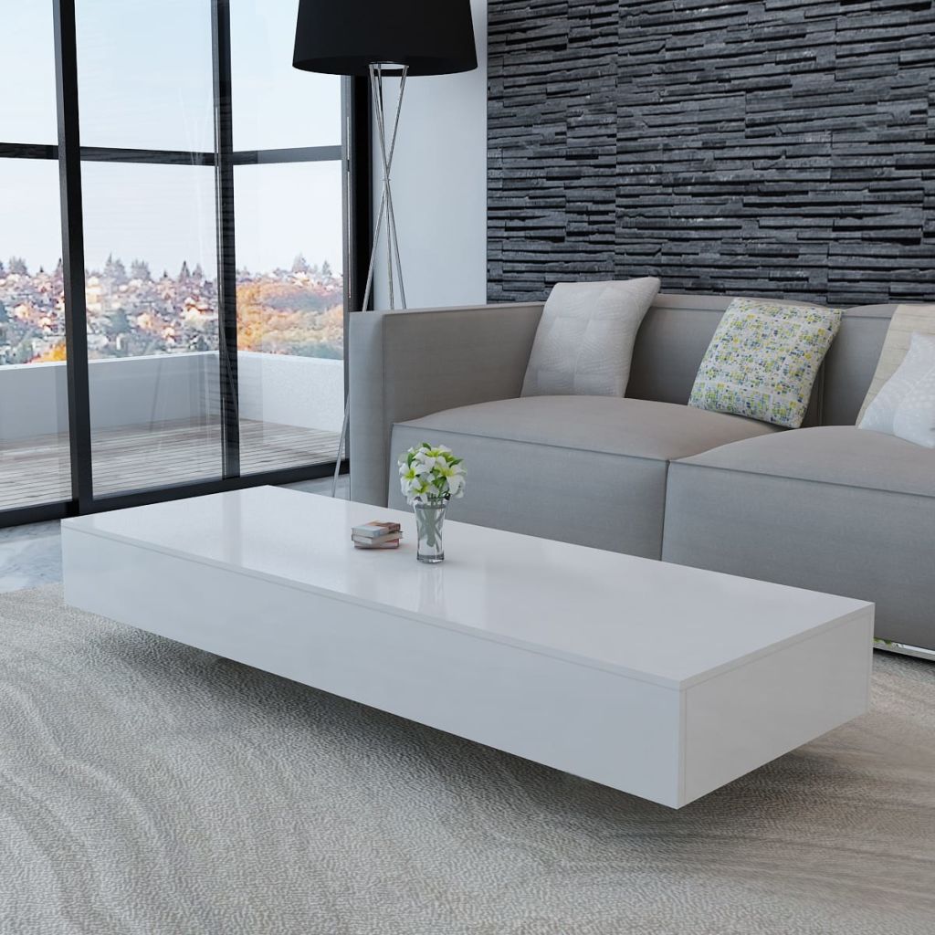 Modern living room with a gray sofa, white coffee table, and decorative pillows.