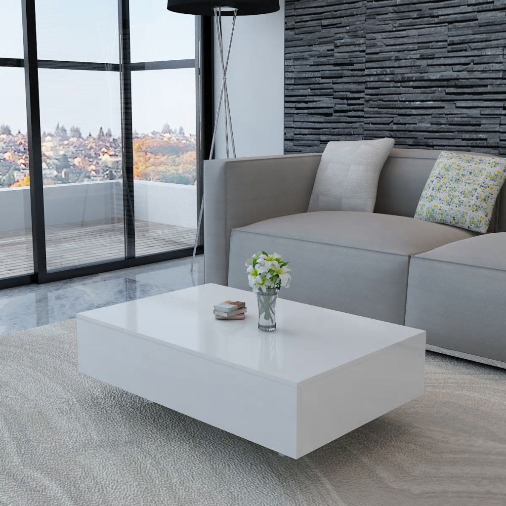 Modern living room with a gray sofa, white coffee table, and decorative elements.