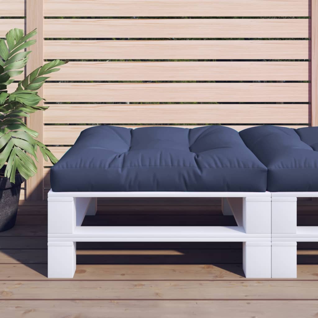 White pallet bench with navy cushions on a wooden deck