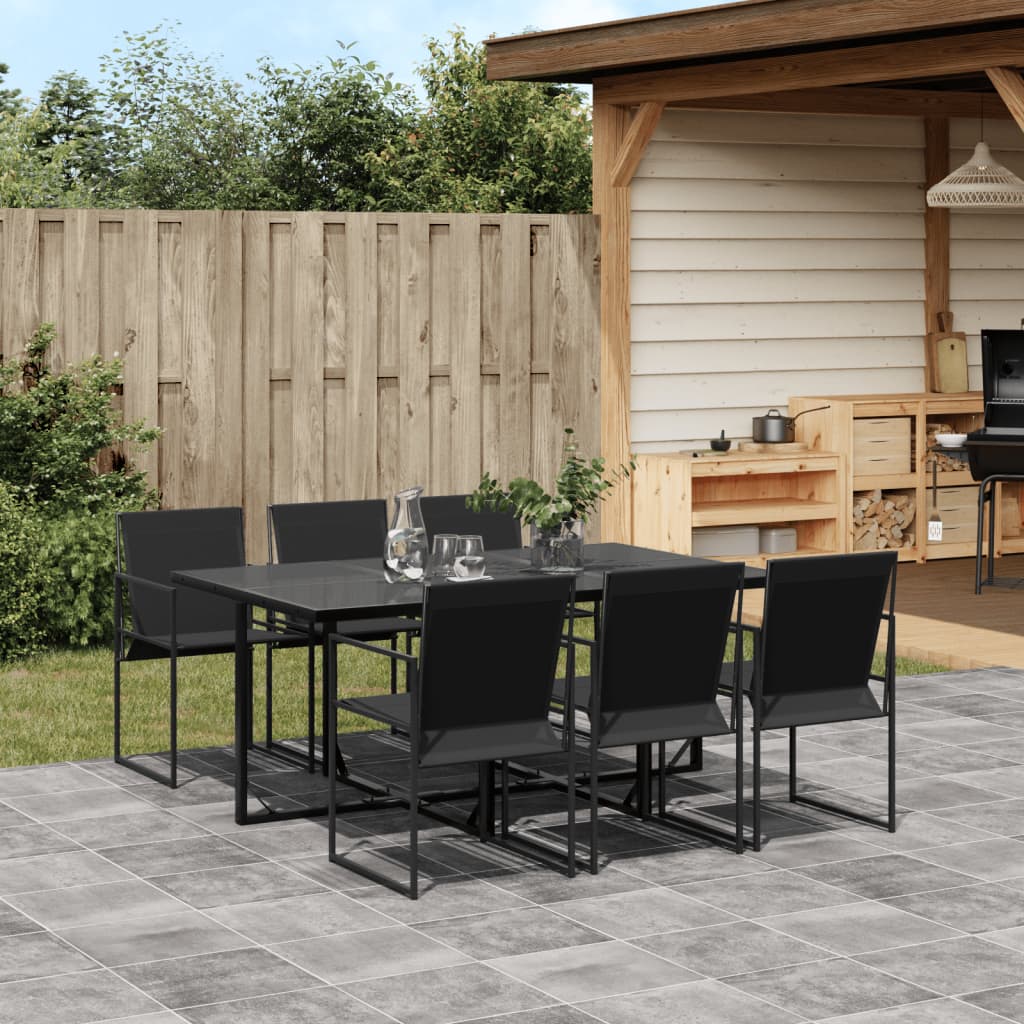 Outdoor patio set with black table and chairs on a tiled patio, wooden fence, and shed in the background.