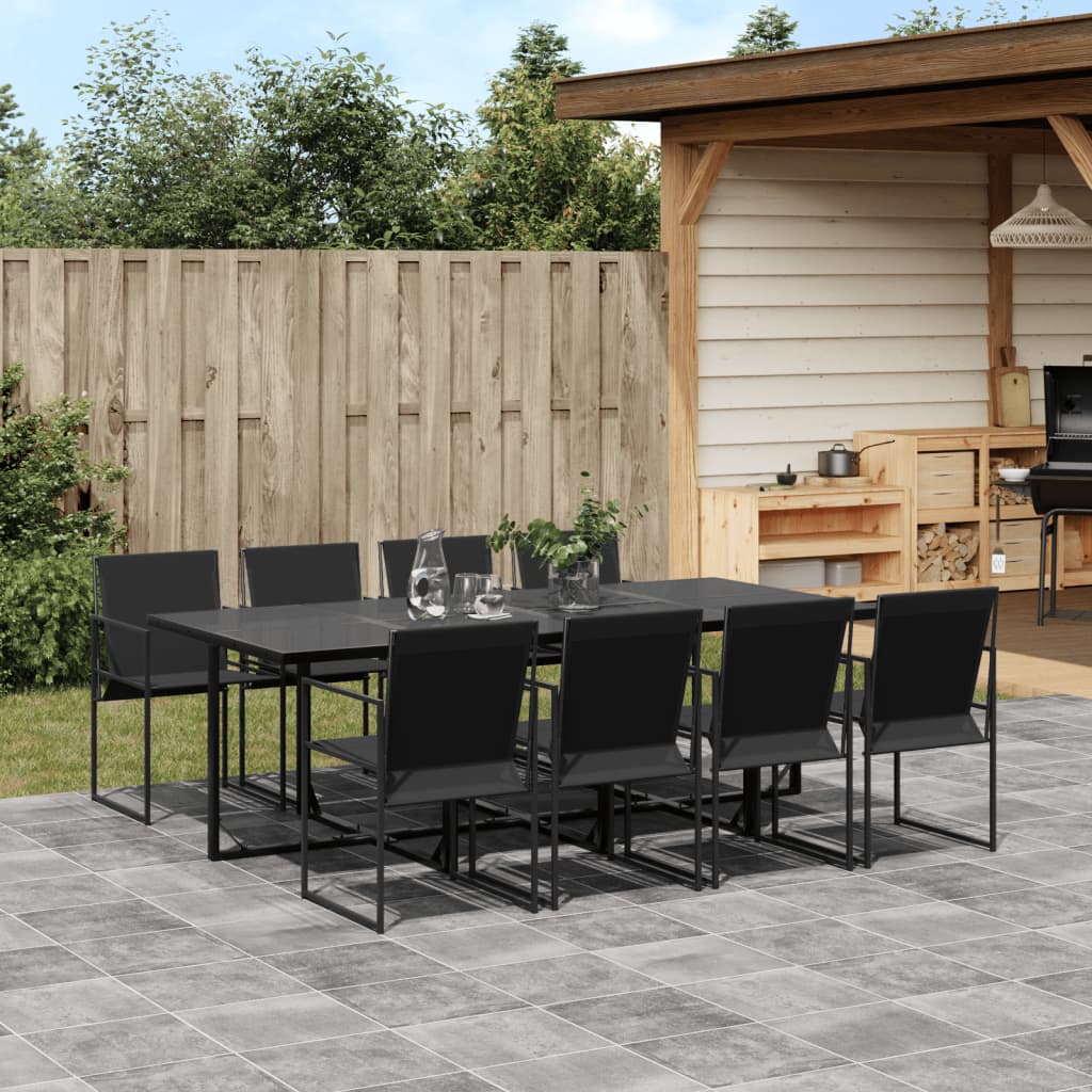 Outdoor patio set with black table and chairs on a tiled patio area.
