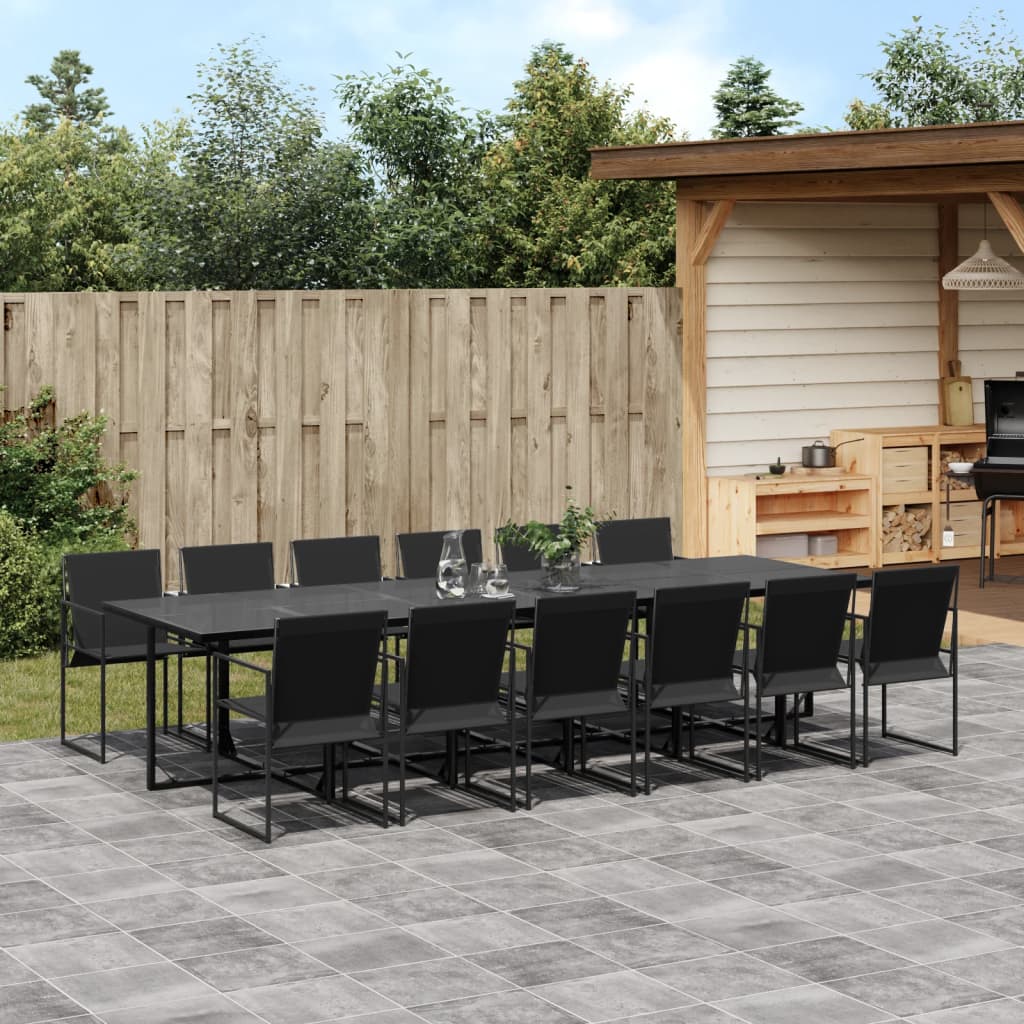 Outdoor patio set with black dining table and chairs on a stone patio.