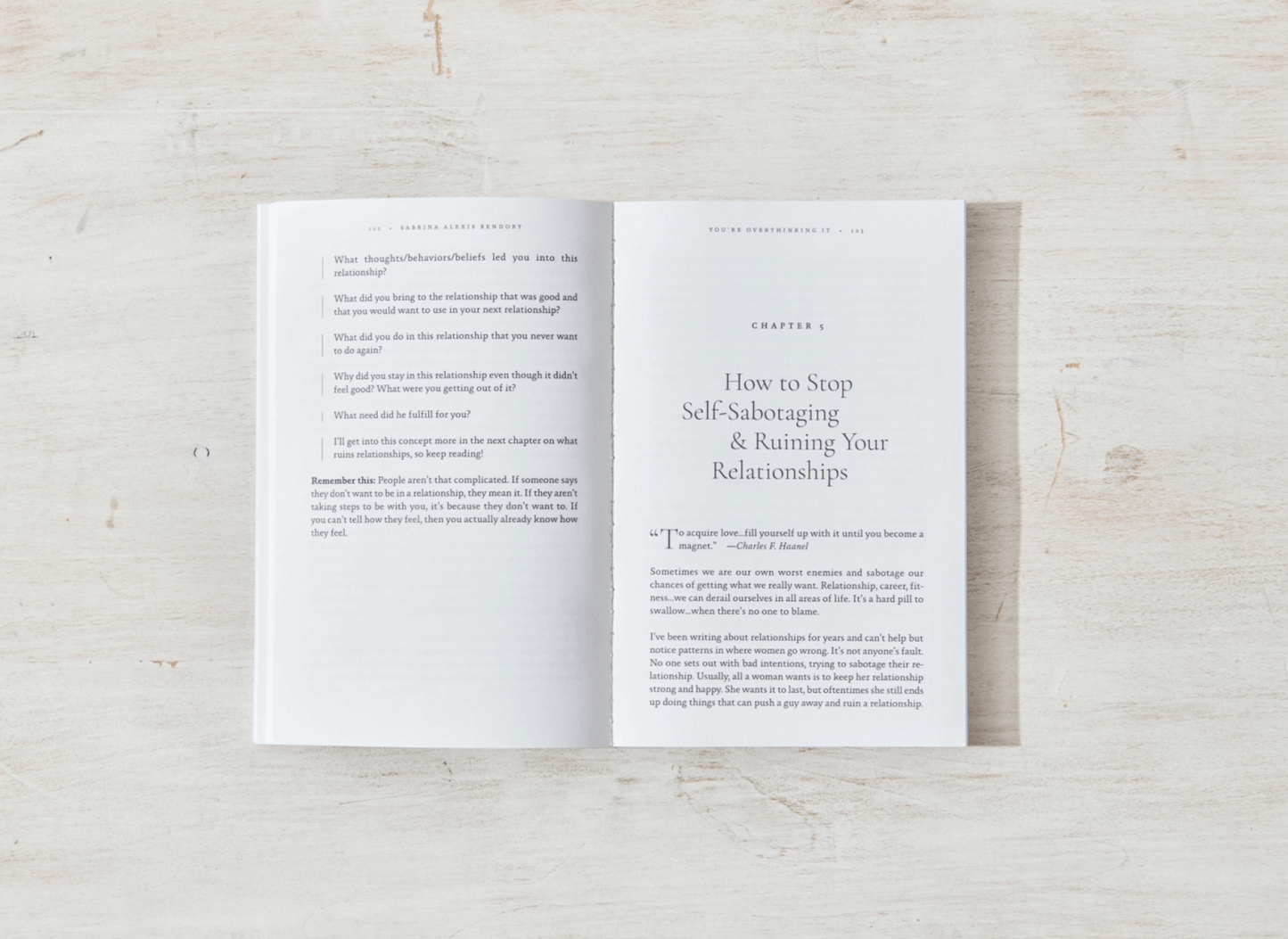 Open book on a light wooden surface with text visible