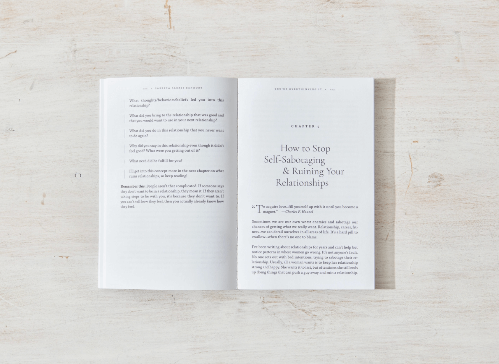 Open book on a light wooden surface with text visible