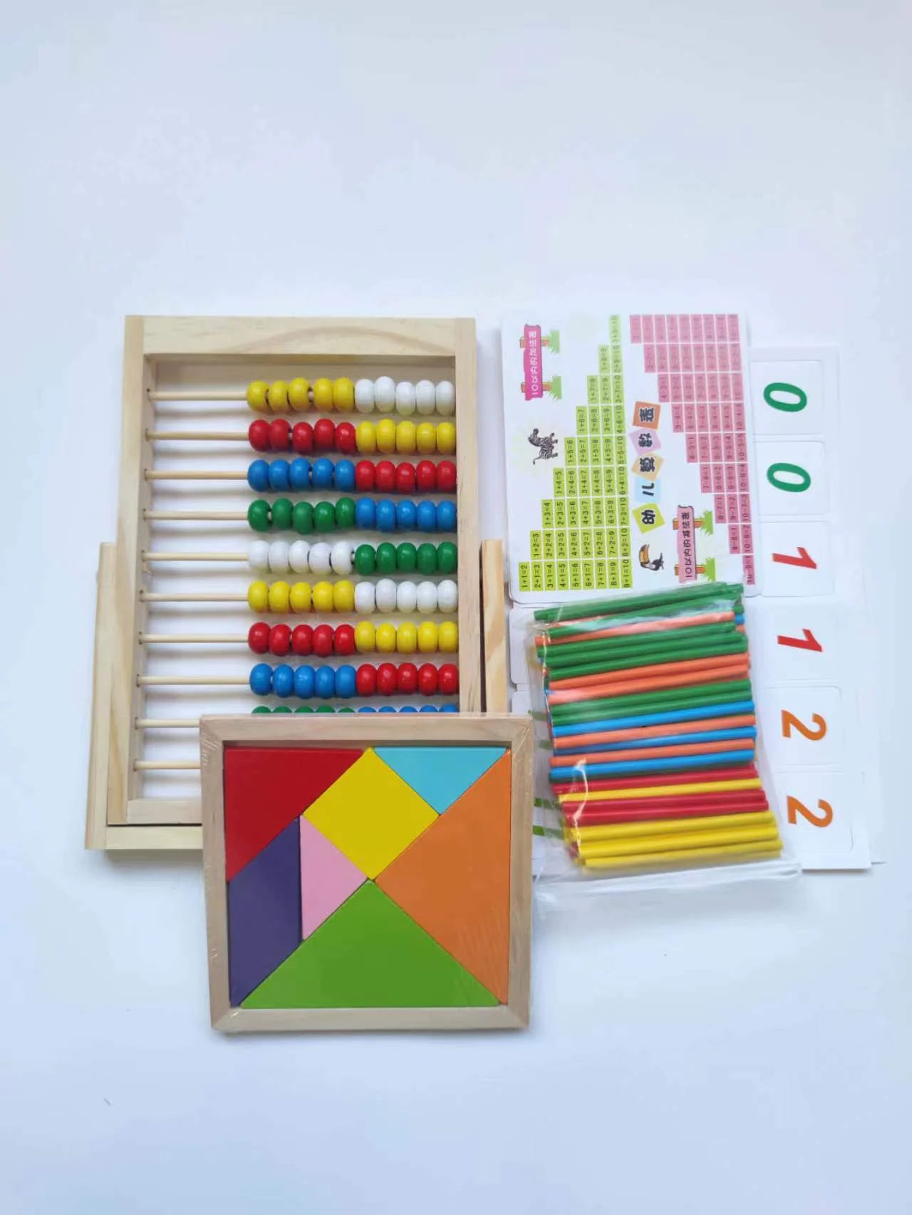 Set of educational toys including a colorful abacus, geometric shapes, and number cards on a white background.