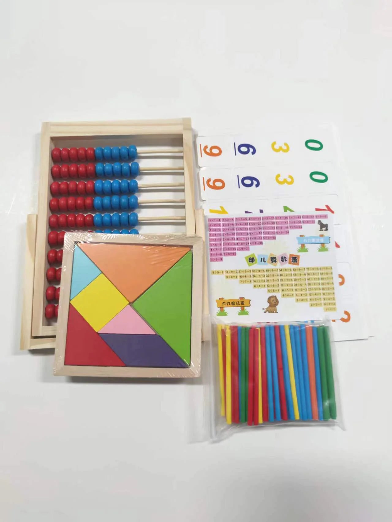 Set of educational toys including a geometric shapes set, abacus, and number cards on a white background.