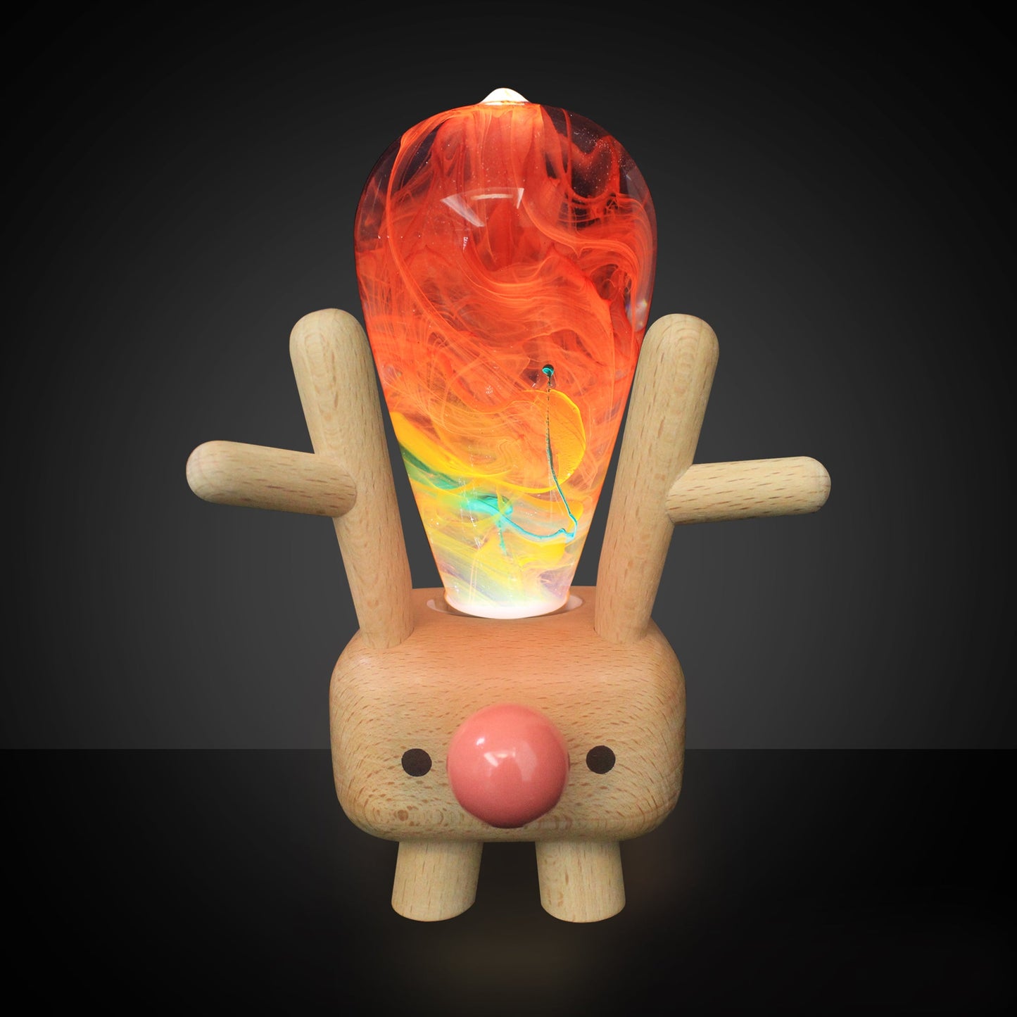 Wooden reindeer figure with a colorful glass ornament on its back against a dark background