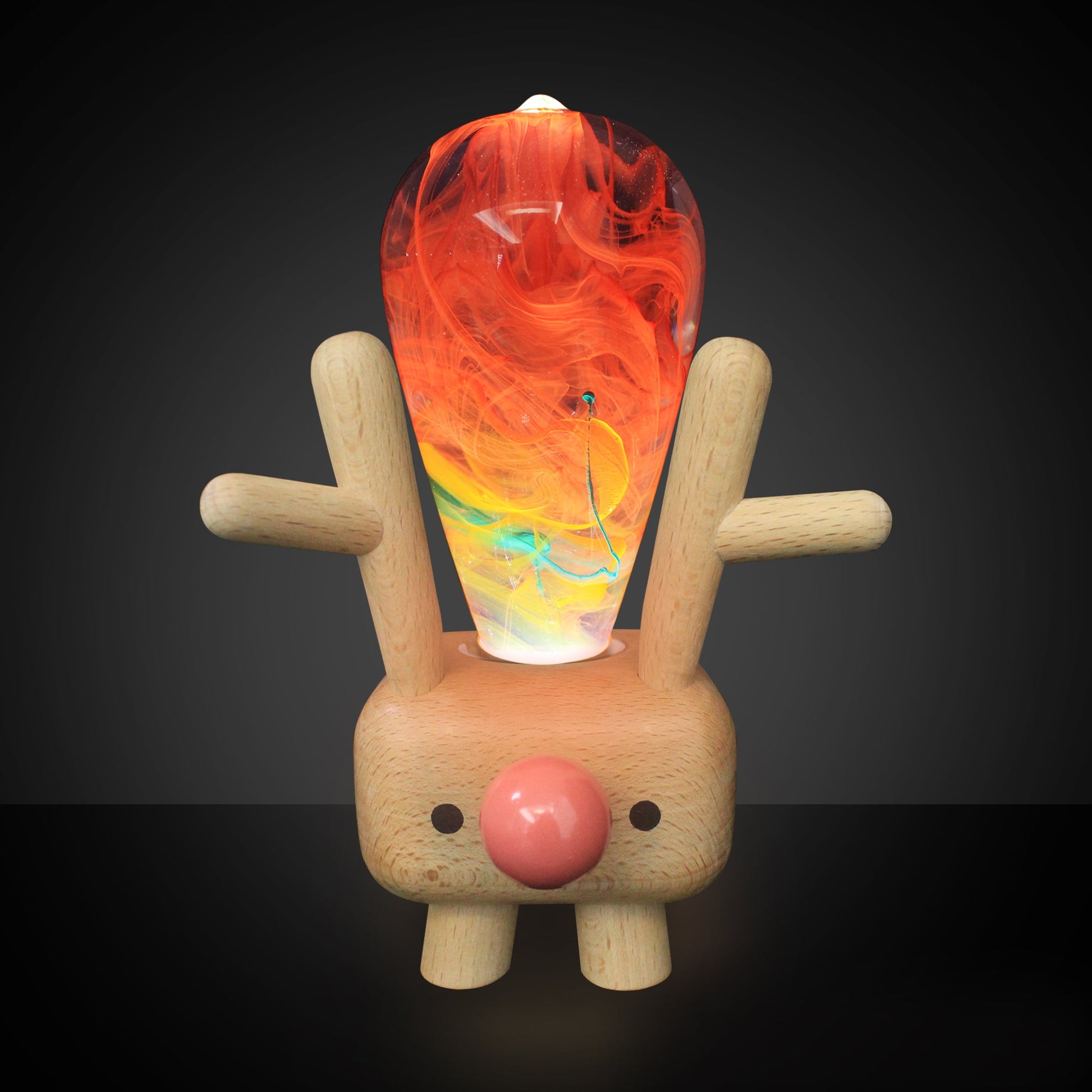 Wooden reindeer figure with a colorful glass ornament on its back against a dark background