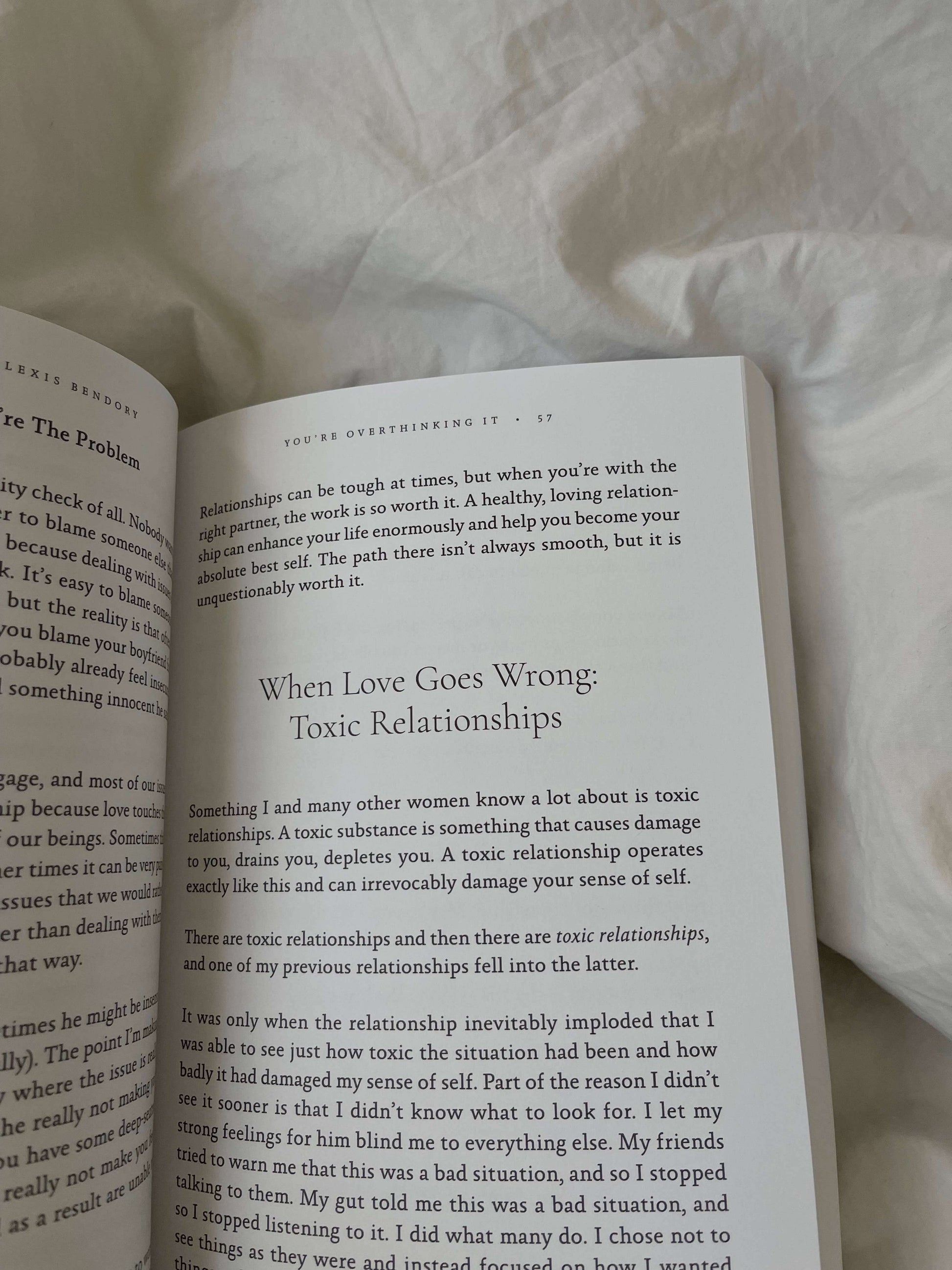 Open book on a light wooden surface with text visible