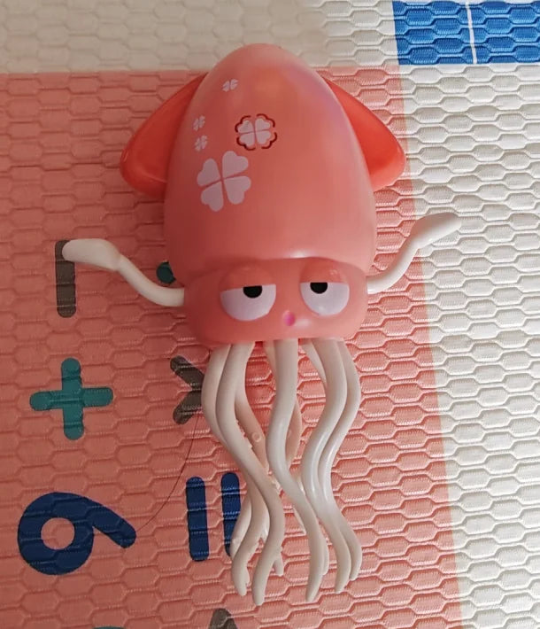 Pink jellyfish toy on a textured surface with letters and numbers.