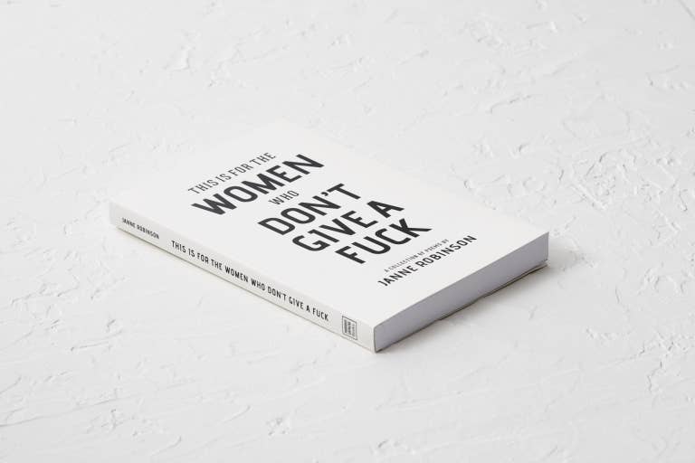 Book titled 'This is for the Women Who Don't Give a F*ck' on a light gray textured surface