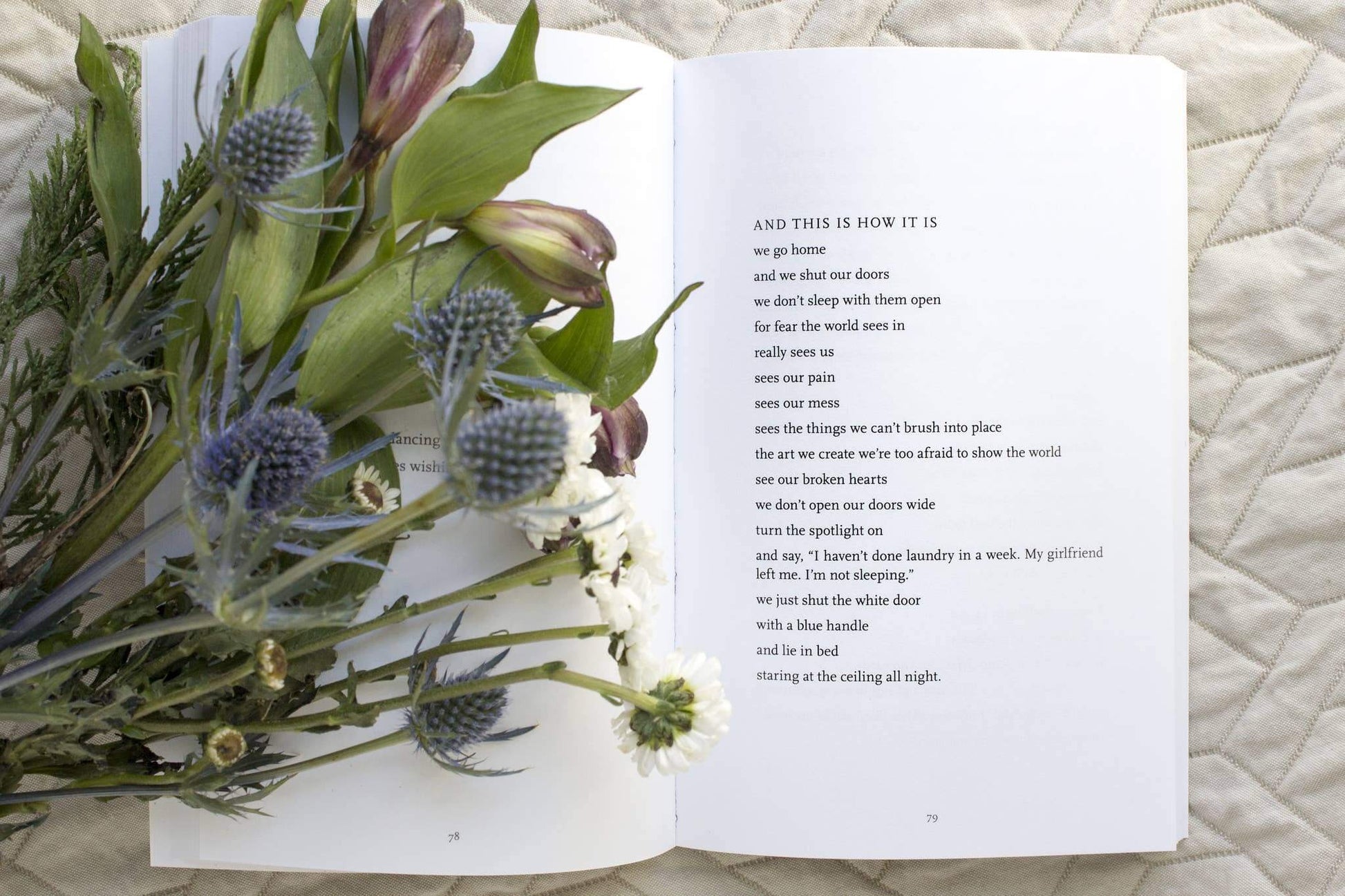 Open book with text and a bouquet of flowers on a textured surface