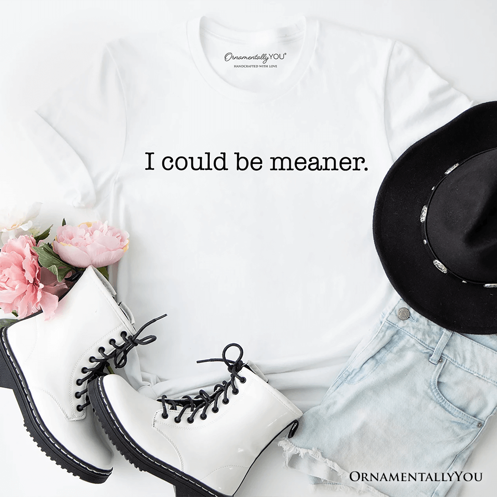 White shirt, black boots, black hat, and pink flowers on a white background with text 'I could be meaner.'