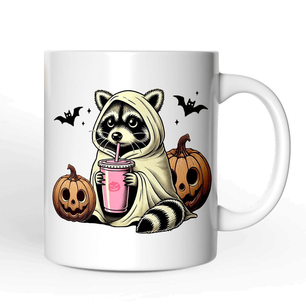 White mug with a raccoon in a hoodie holding a pink drink, surrounded by pumpkins and bats on a black background.