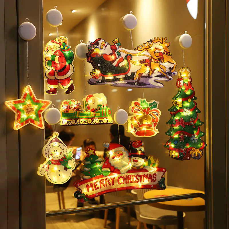Decorative Christmas window stickers with Santa Claus, reindeer, and other festive elements on a glass surface.