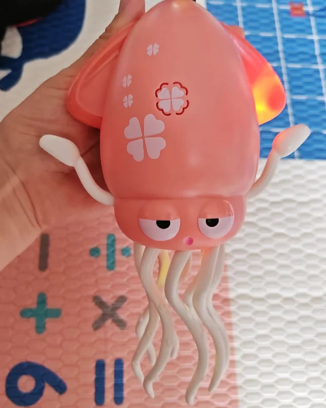 Pink octopus-shaped toy held by a hand on a colorful background