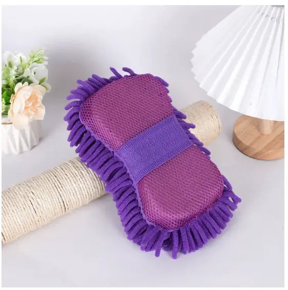 Purple cleaning brush with bristles on a white surface