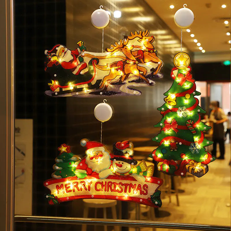 Decorative Christmas lights with Santa Claus, reindeer, and tree on a reflective surface.