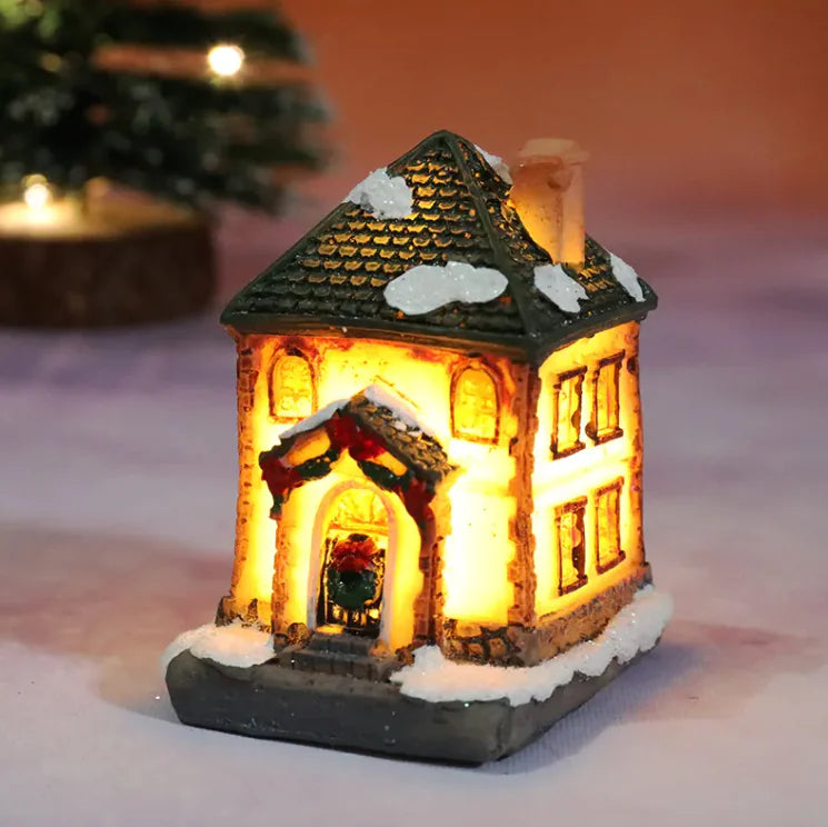 Decorative miniature house with lights on a snowy surface